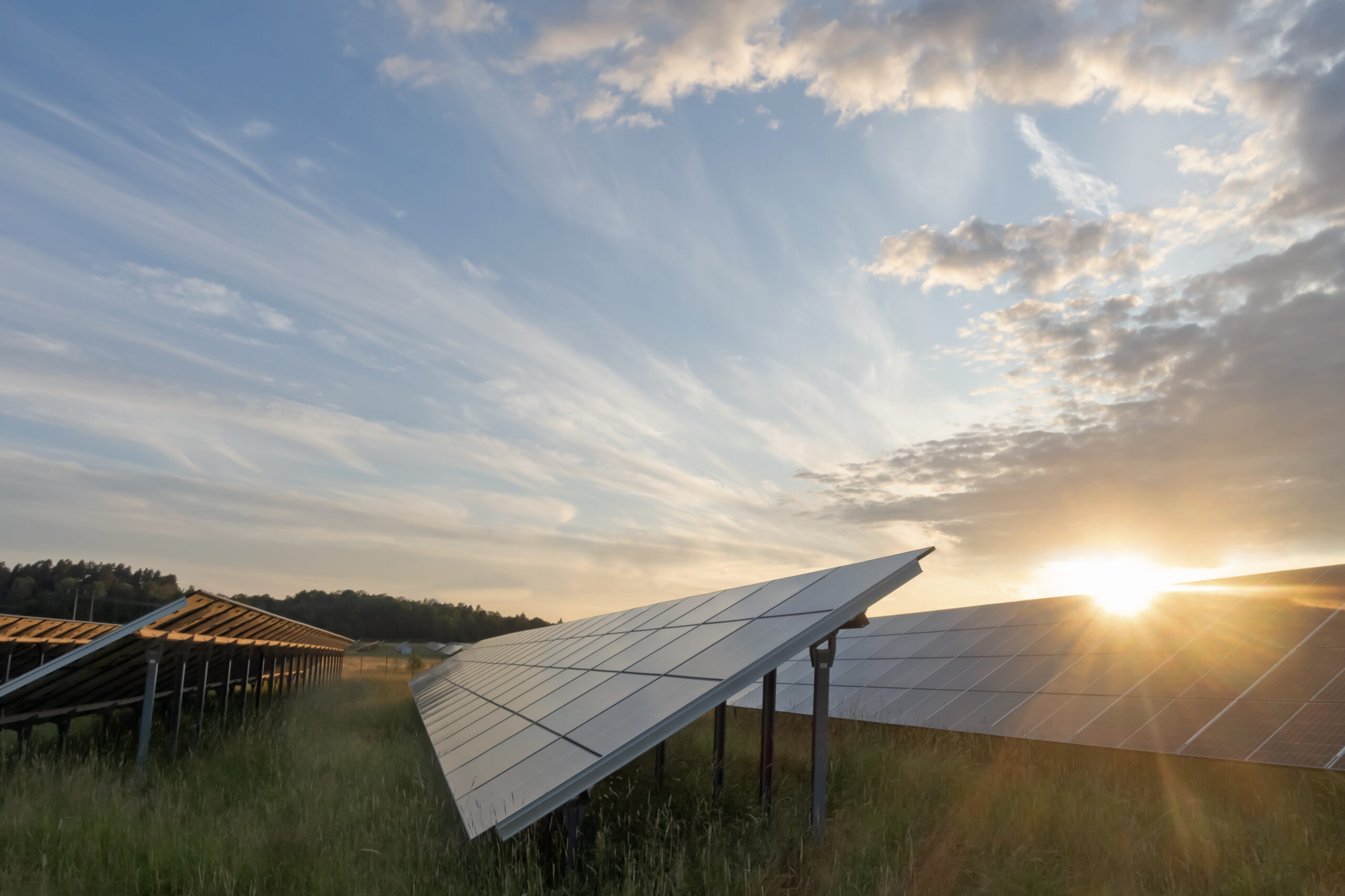 Solar panels at orange sunset, with blue sky